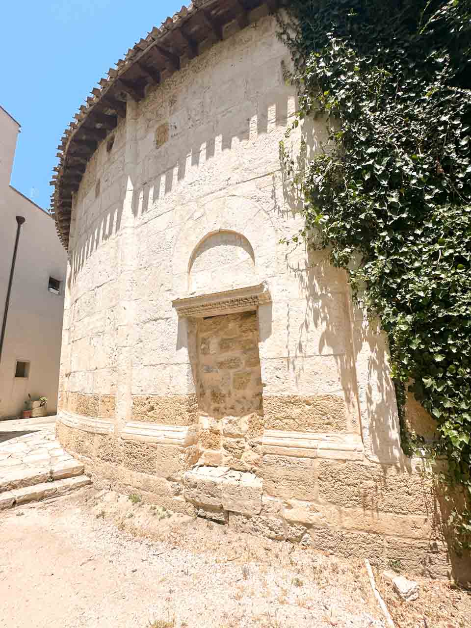 The Church of San Giovanni al Sepolcro in Brindisi, partly covered in ivy, with a blocked arched doorway