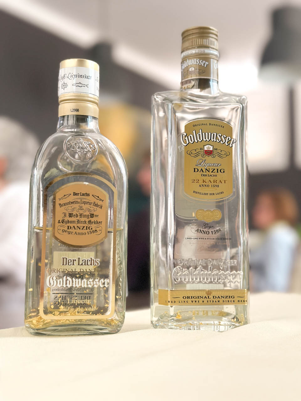 Two bottles of Der Lachs Goldwasser liqueur with floating gold flakes, labelled “Original Danzig”