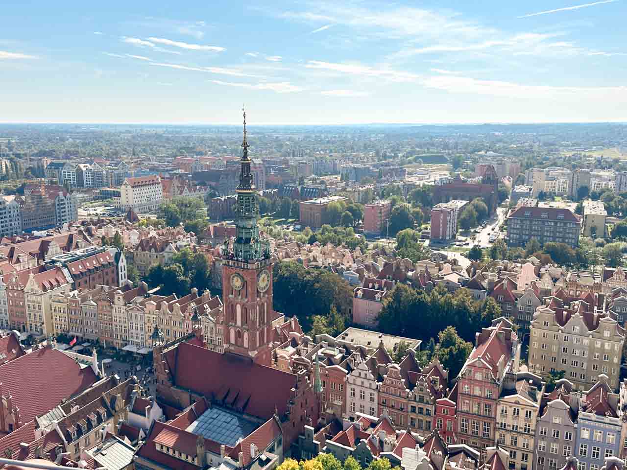 Panoramic view of Gdańsk’s Main Town Hall and cityscape, with the clock tower rising above the trees