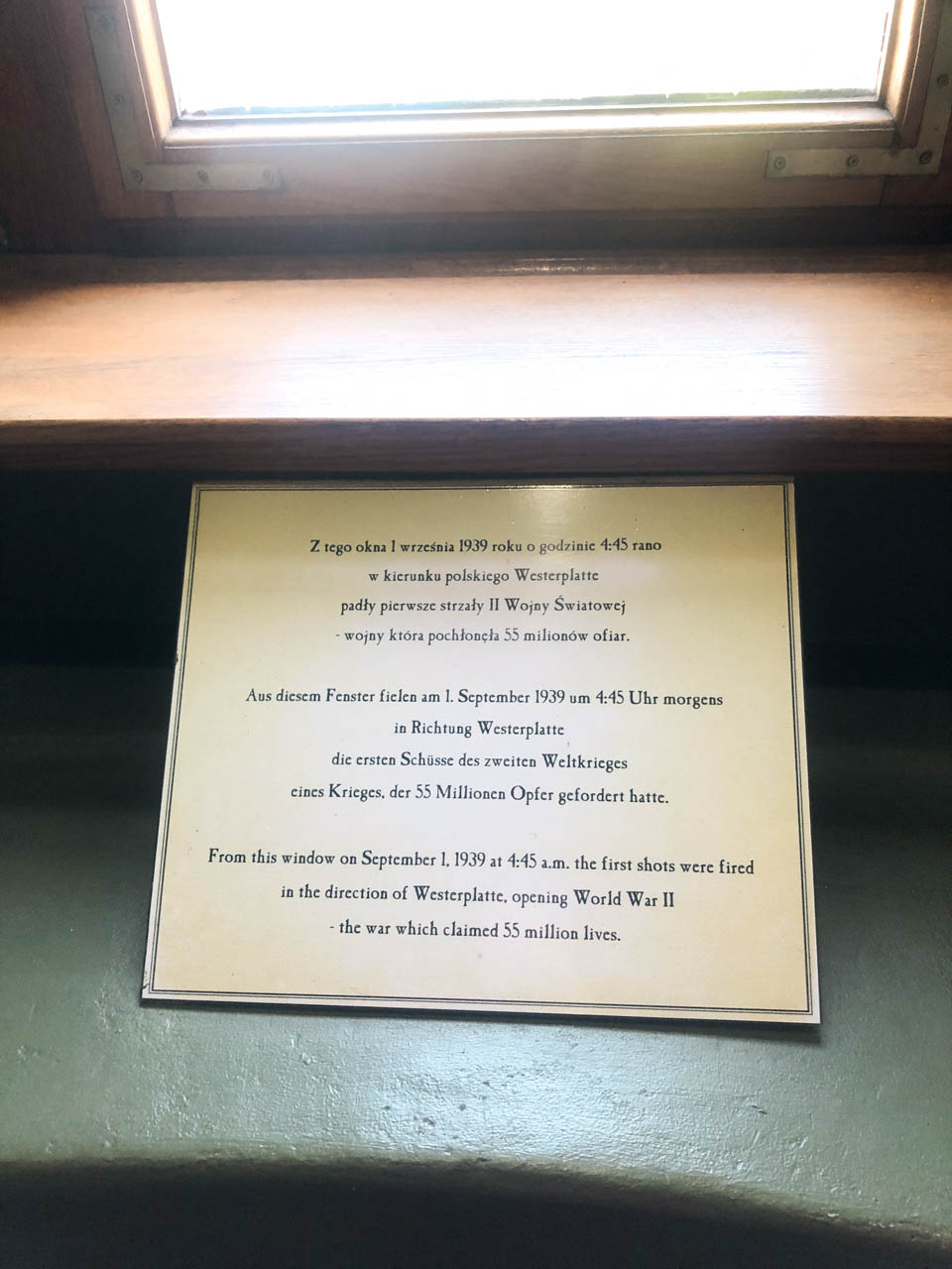 A plaque under a window at Nowy Port Lighthouse, marking the first shots fired in WWII towards Westerplatte