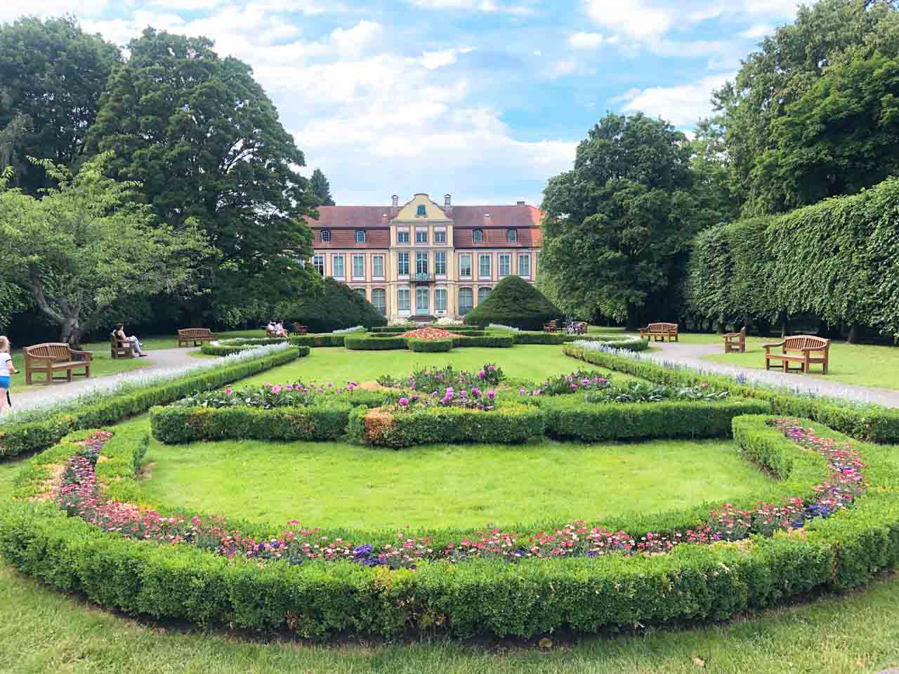 Beautifully maintained garden with flower beds and benches in front of the Abbots’ Palace in Oliwa