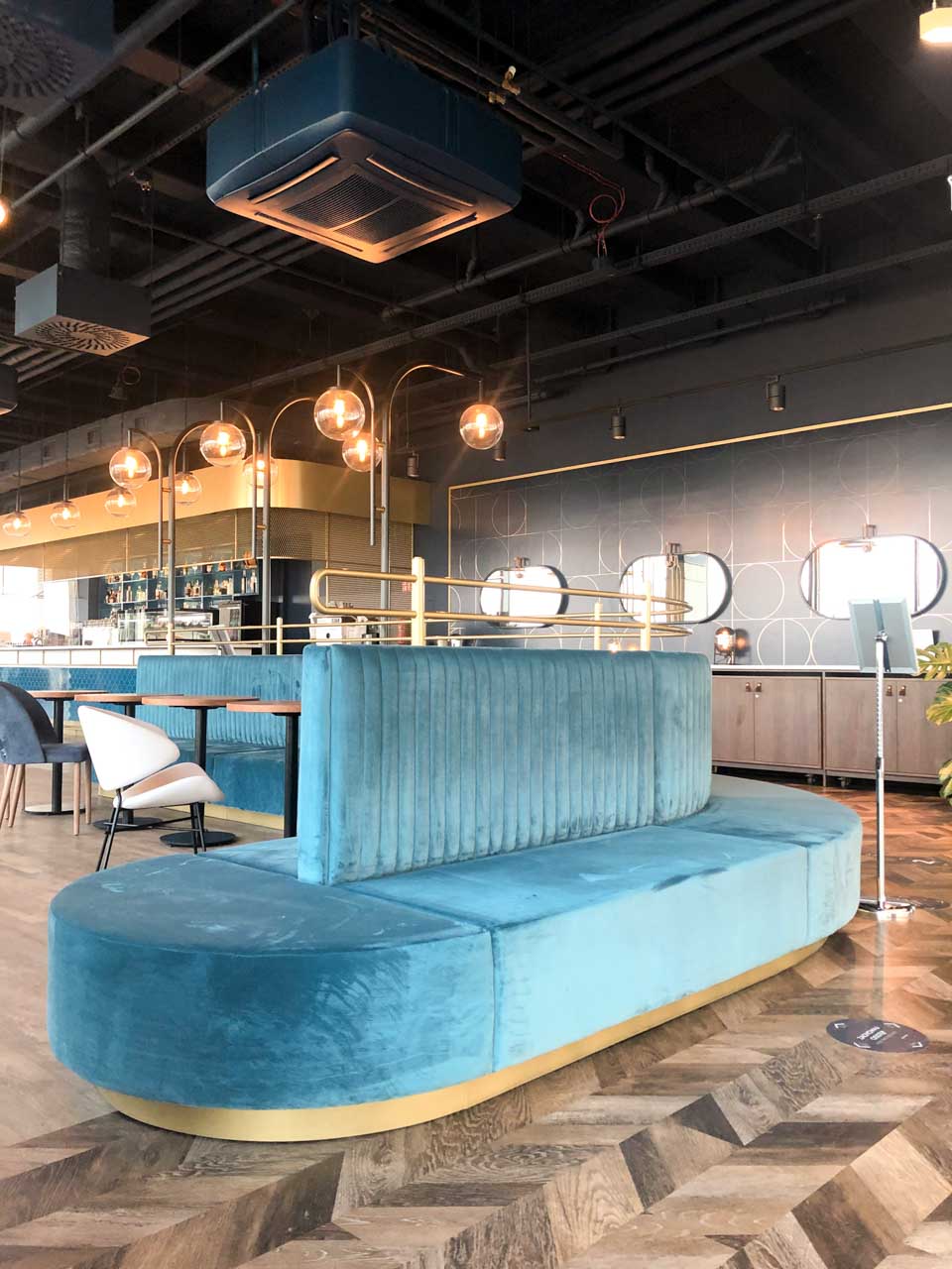 Turquoise velvet seating inside Vidokówka, the restaurant at Olivia Star in Gdańsk