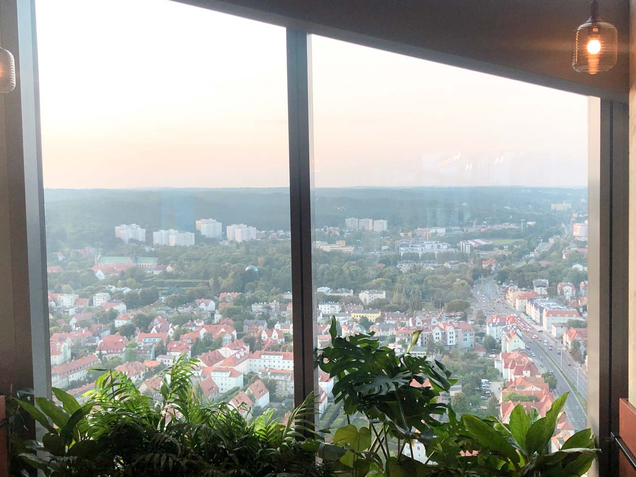 Panoramic view over Gdańsk from Vidokówka at Olivia Star, with leafy plants by the window