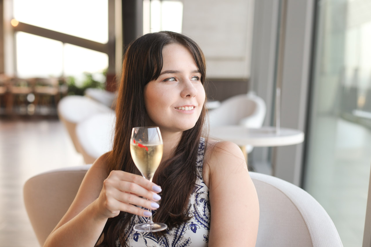 A young woman holding a glass of G.H. Mumm champagne at Vidokówka, inside the Olivia Star building
