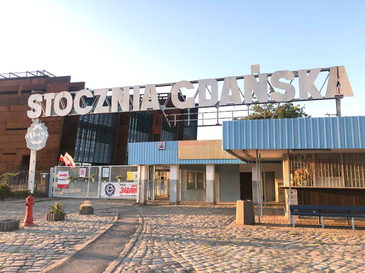 The famous 'Stocznia Gdańska' gate, symbol of the Solidarity movement, lit by evening sun