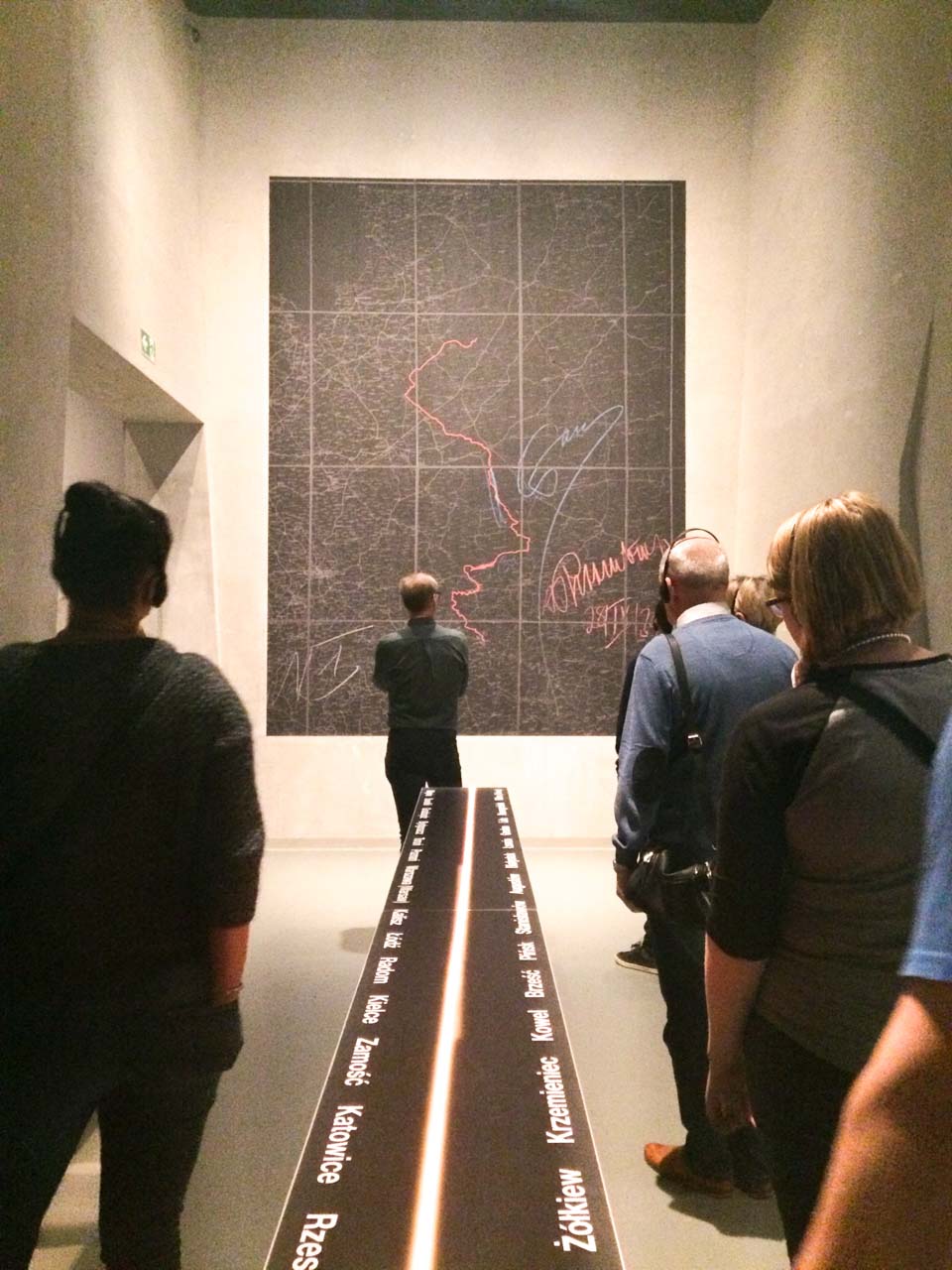 Visitors observing a large map installation at the Museum of the Second World War in Gdańsk