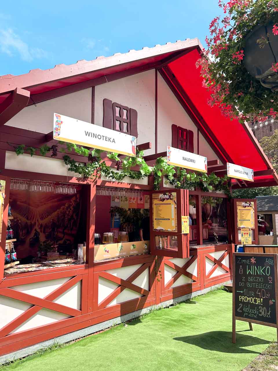 A wooden wine stall at St. Dominic’s Fair in Gdańsk, decorated with vines and handwritten chalkboard signs