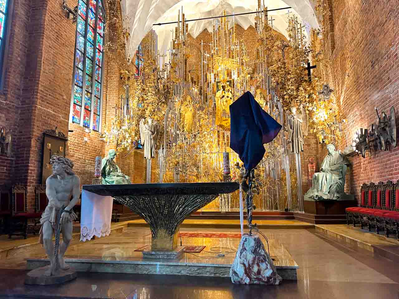Amber altar inside St. Bridget’s Church in Gdańsk, framed by red brick walls and stained glass