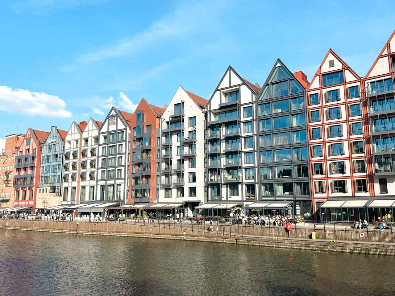 Modern buildings along the Motława River in Gdańsk, designed to resemble historic granaries