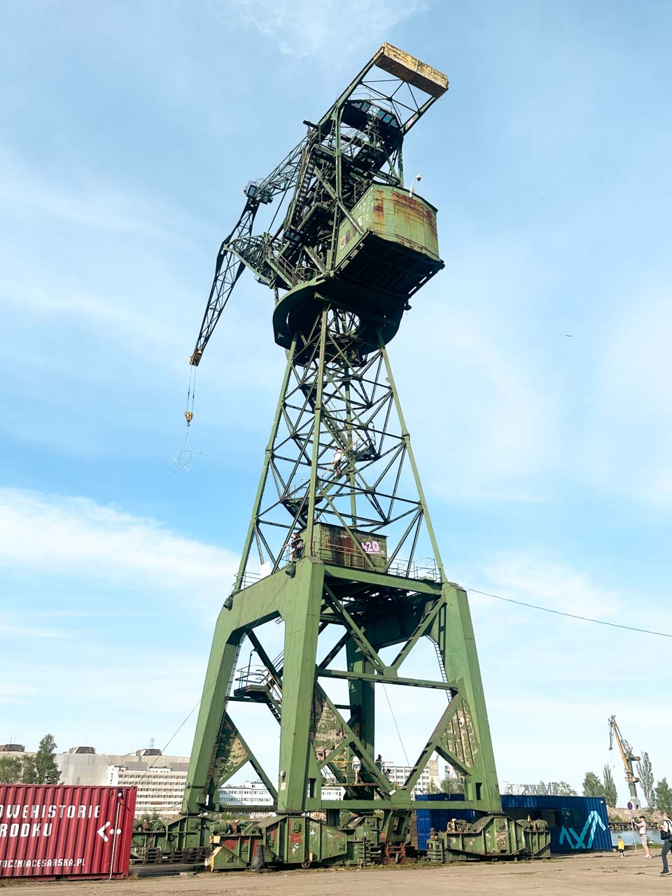 Close-up of a tall green shipyard crane with rusted elements, part of Gdańsk’s historic Imperial Shipyard