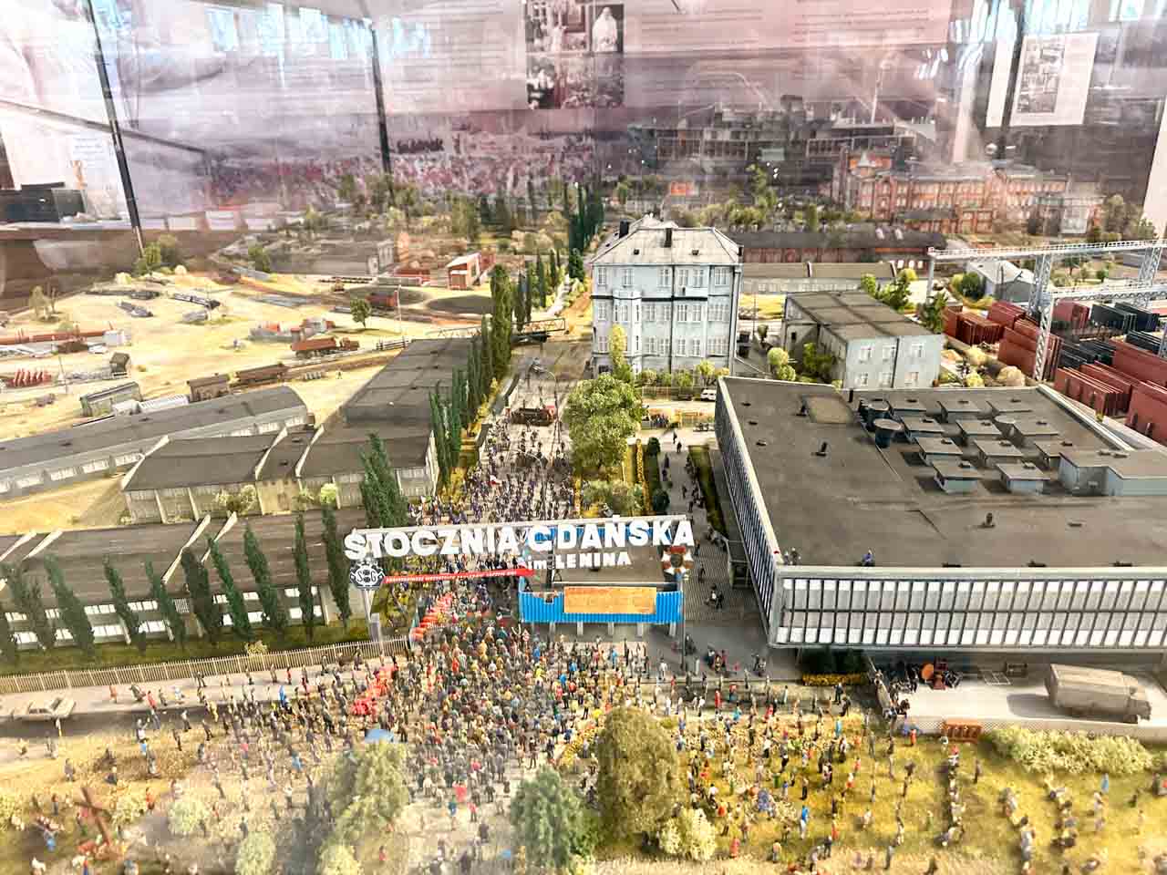 Detailed miniature model of the Gdańsk Shipyard with a crowd gathered by the main gate