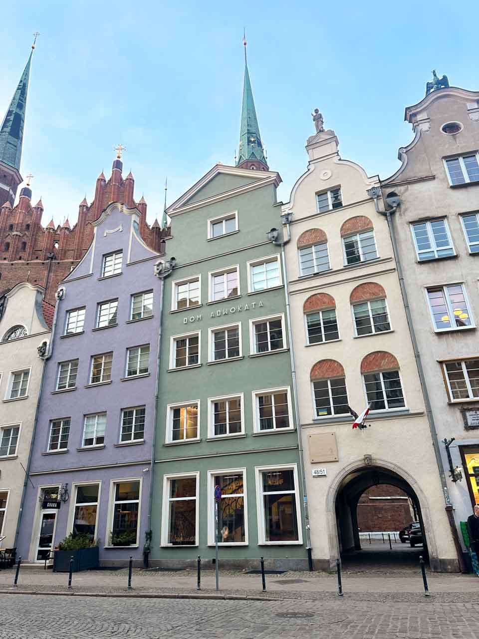 Dom Adwokata and neighbouring tenement houses with green spires of St. Mary’s Church behind them