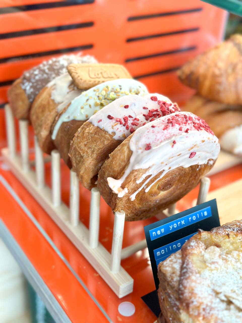 A display of colourful New York rolls with toppings like pistachios and Biscoff, inside Kompozyt Cafe in Gdańsk