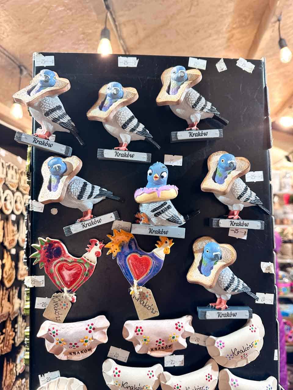 Fridge magnets of pigeons with bread around their necks and other Krak&oacute;w-themed souvenirs at the Krak&oacute;w Christmas market