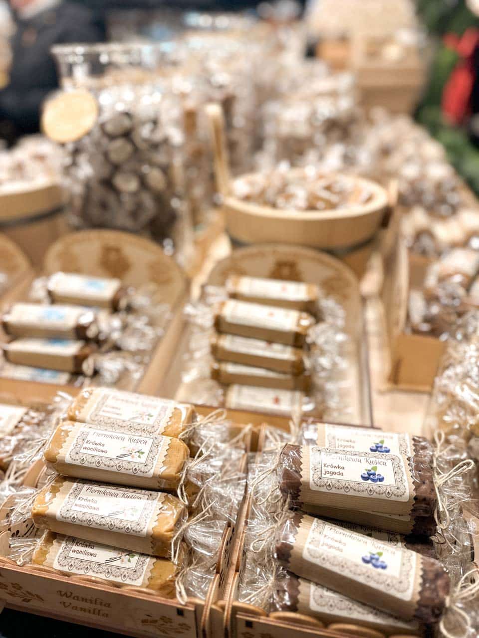Wrapped Polish fudge in flavours like vanilla and blueberry displayed in wooden trays at the Krak&oacute;w Christmas market