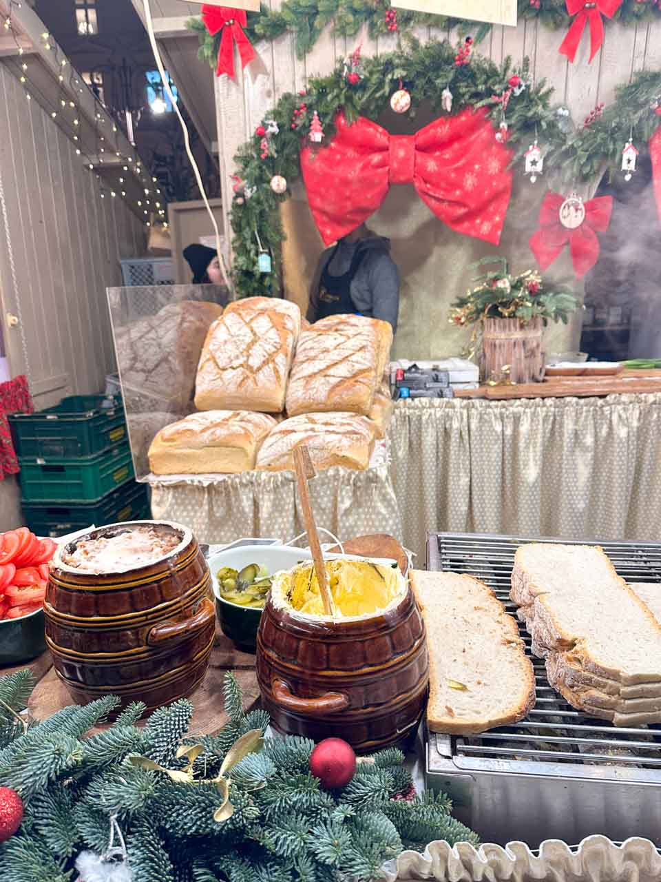 Slices of fresh sourdough bread and toppings like lard and pickles at a rustic sandwich stall at the Krak&oacute;w Christmas market