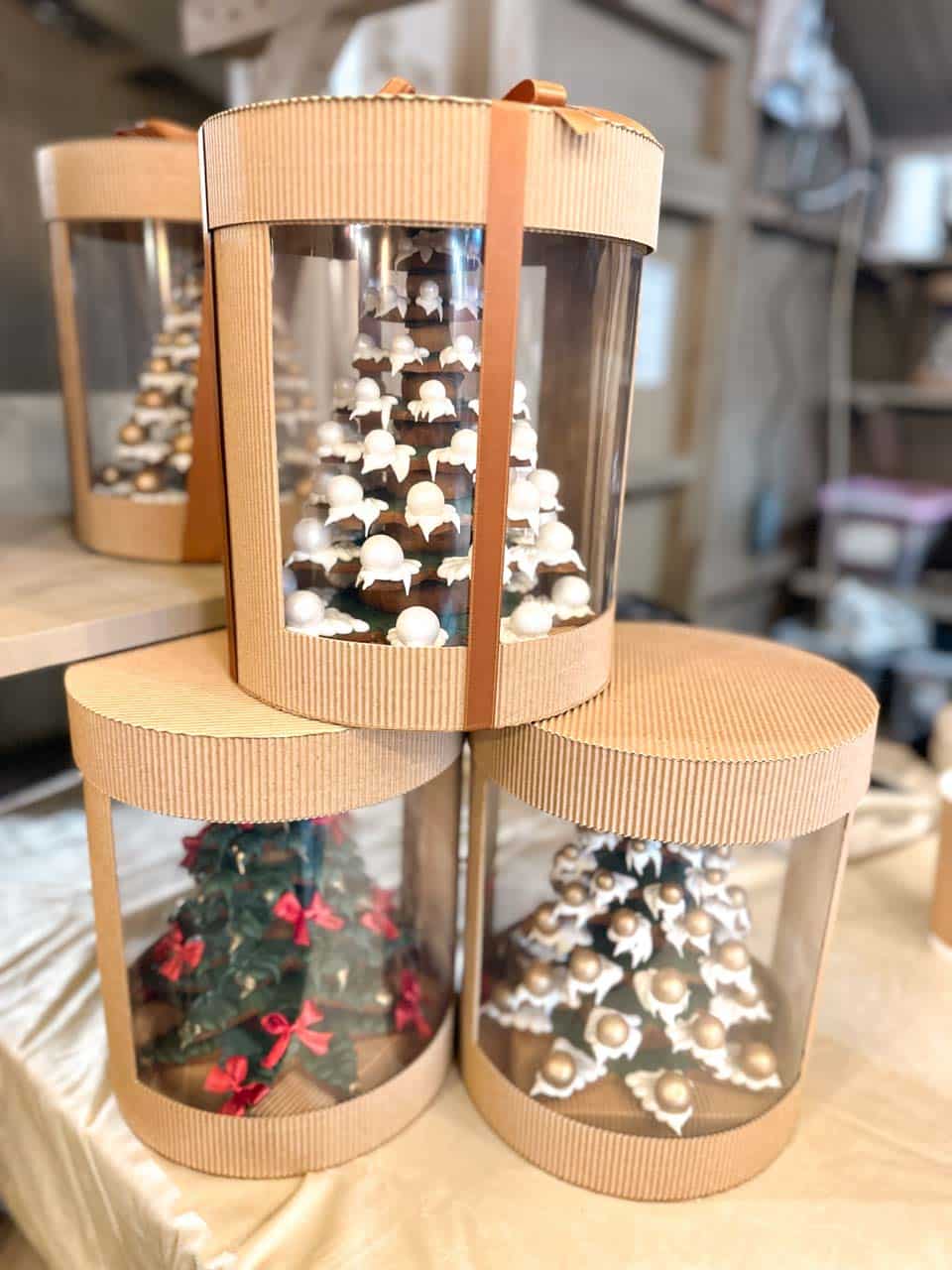 Three gingerbread Christmas trees decorated with icing and ribbons, packed in round gift boxes with clear panels at the Krak&oacute;w Christmas market