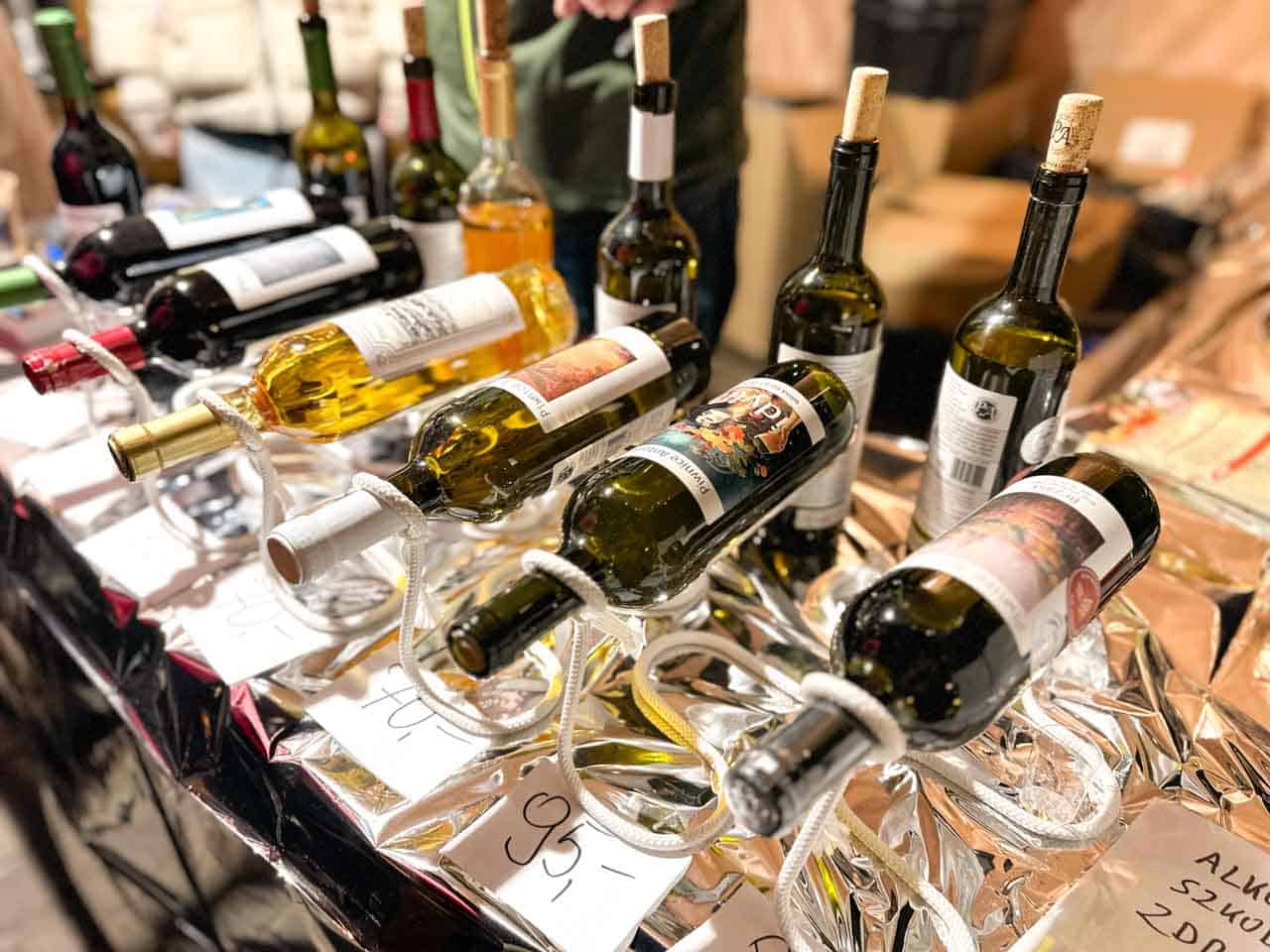 Bottles of wine resting on glass holders, each with a different label and a price tag visible underneath