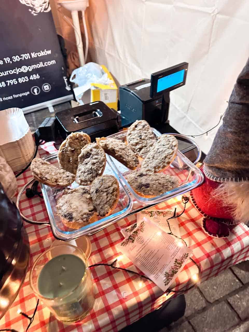 Slices of grilled bread topped with a spread served on a tray on a red and white checked tablecloth at the Krak&oacute;w Christmas market