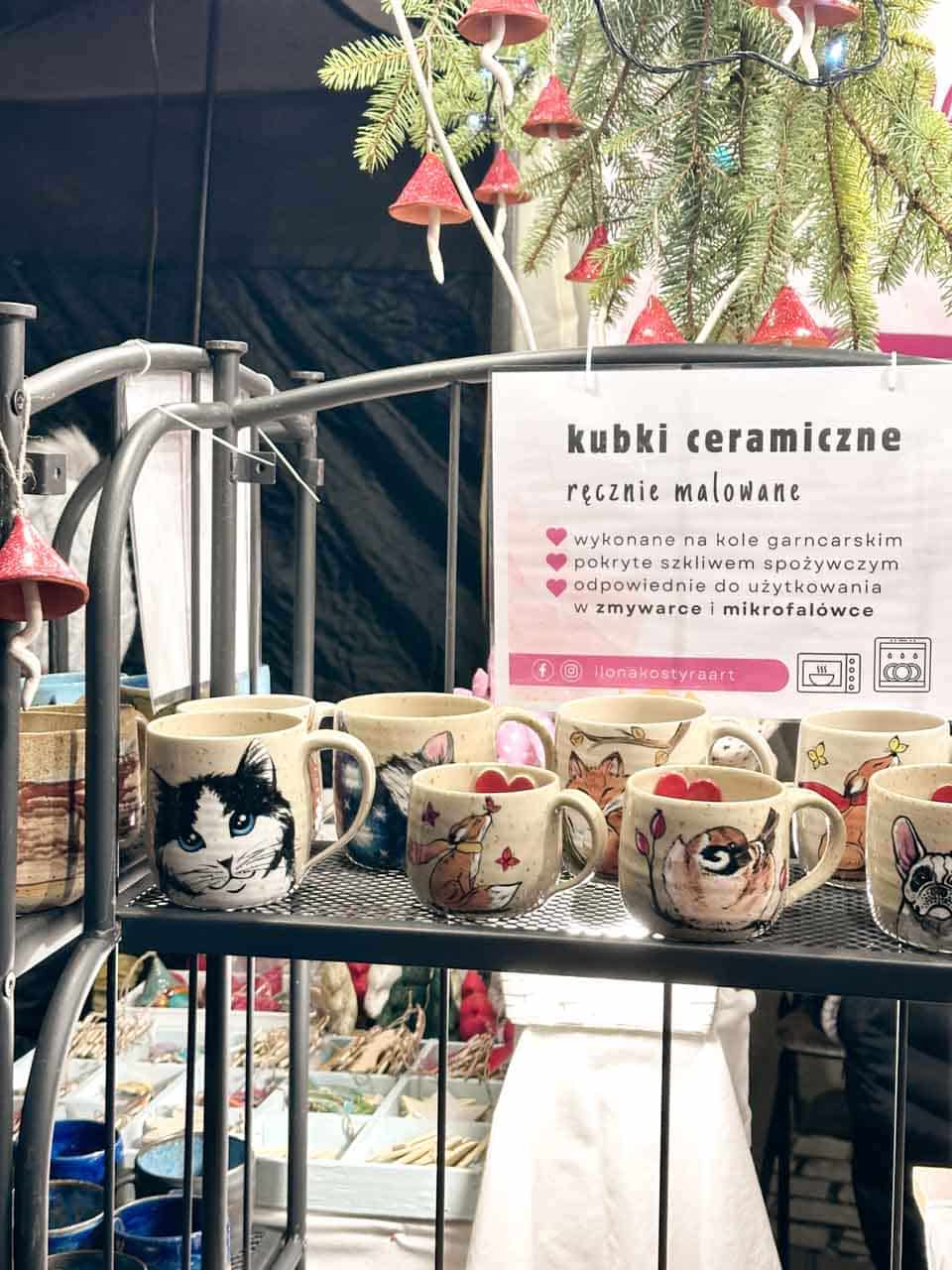 Hand-painted ceramic mugs with animal illustrations displayed at the Podg&oacute;rze Christmas Fair of Unique Items in Krak&oacute;w