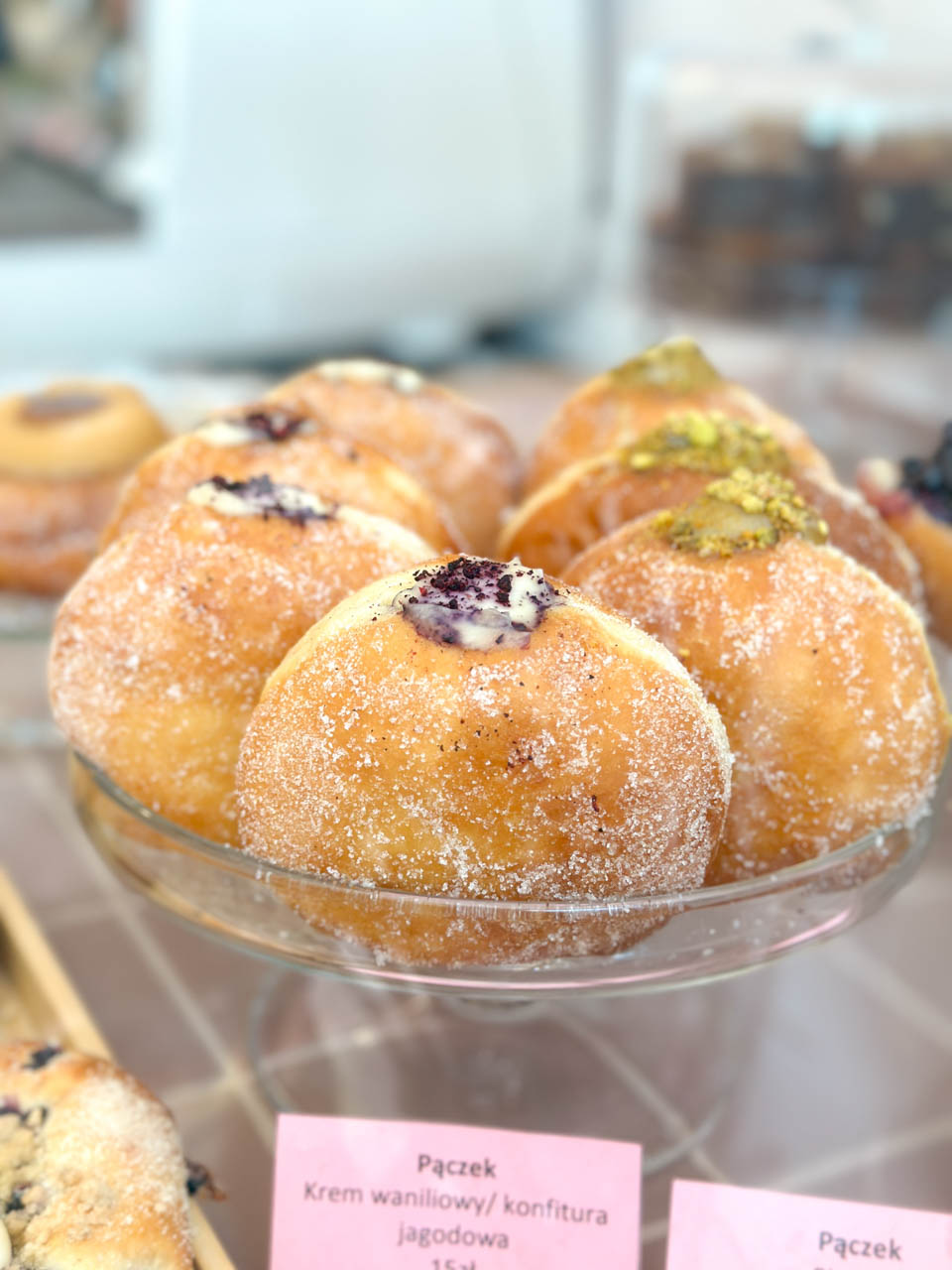 Selection of filled doughnuts with different toppings in a bakery display at Bez&oacute;wka in Gdańsk