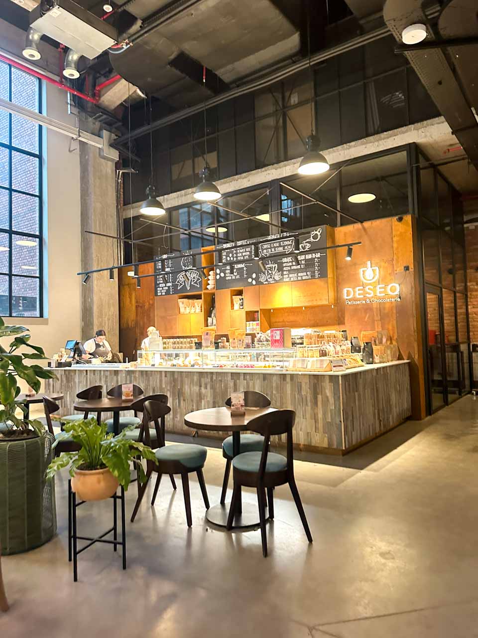 Industrial-style interior of Deseo caf&eacute; in Gdańsk with a counter, seating area, and tall windows