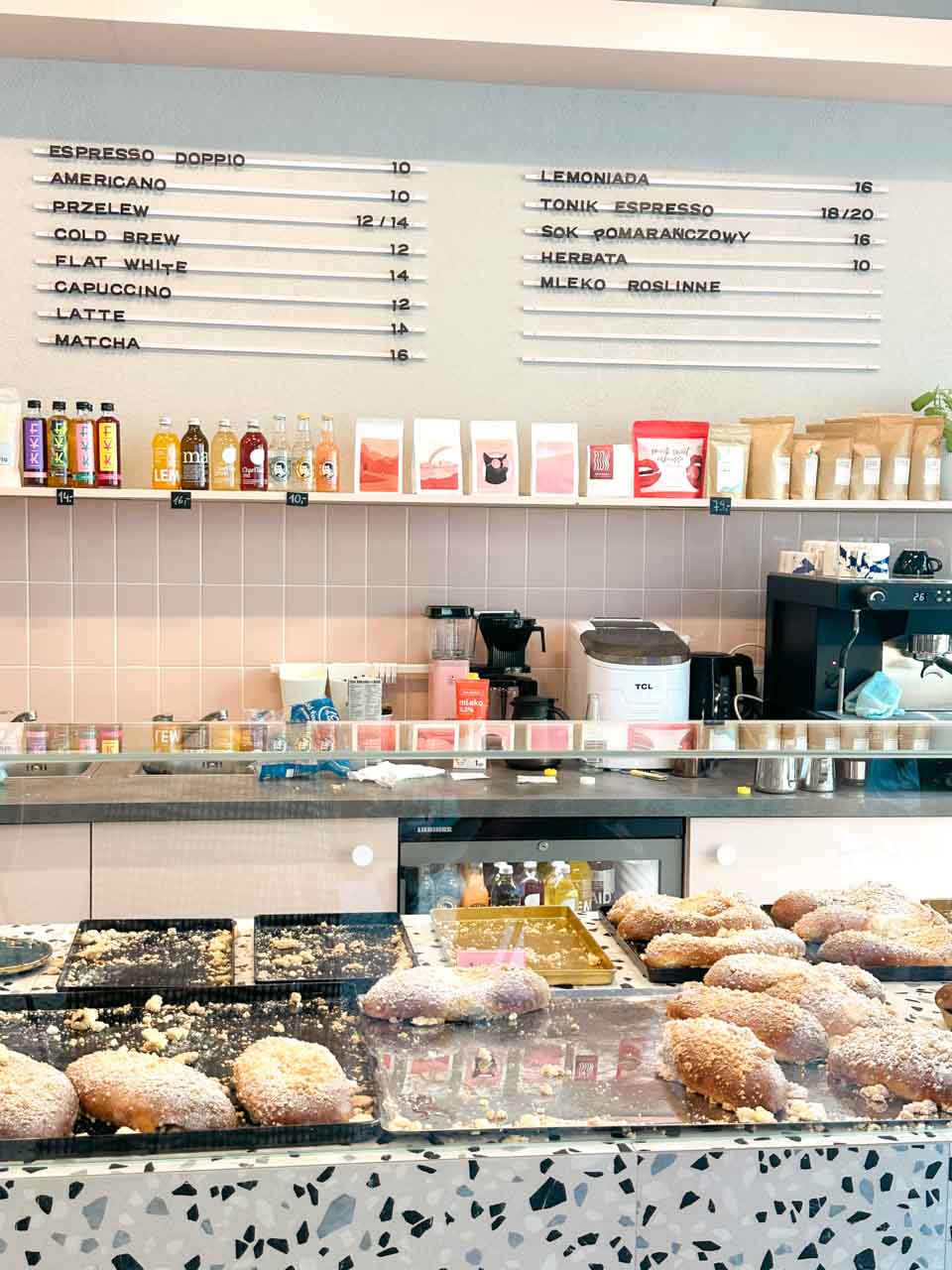 Bakery counter at Must Bake in Gdańsk with trays of sugar-coated bilberry buns and coffee equipment behind