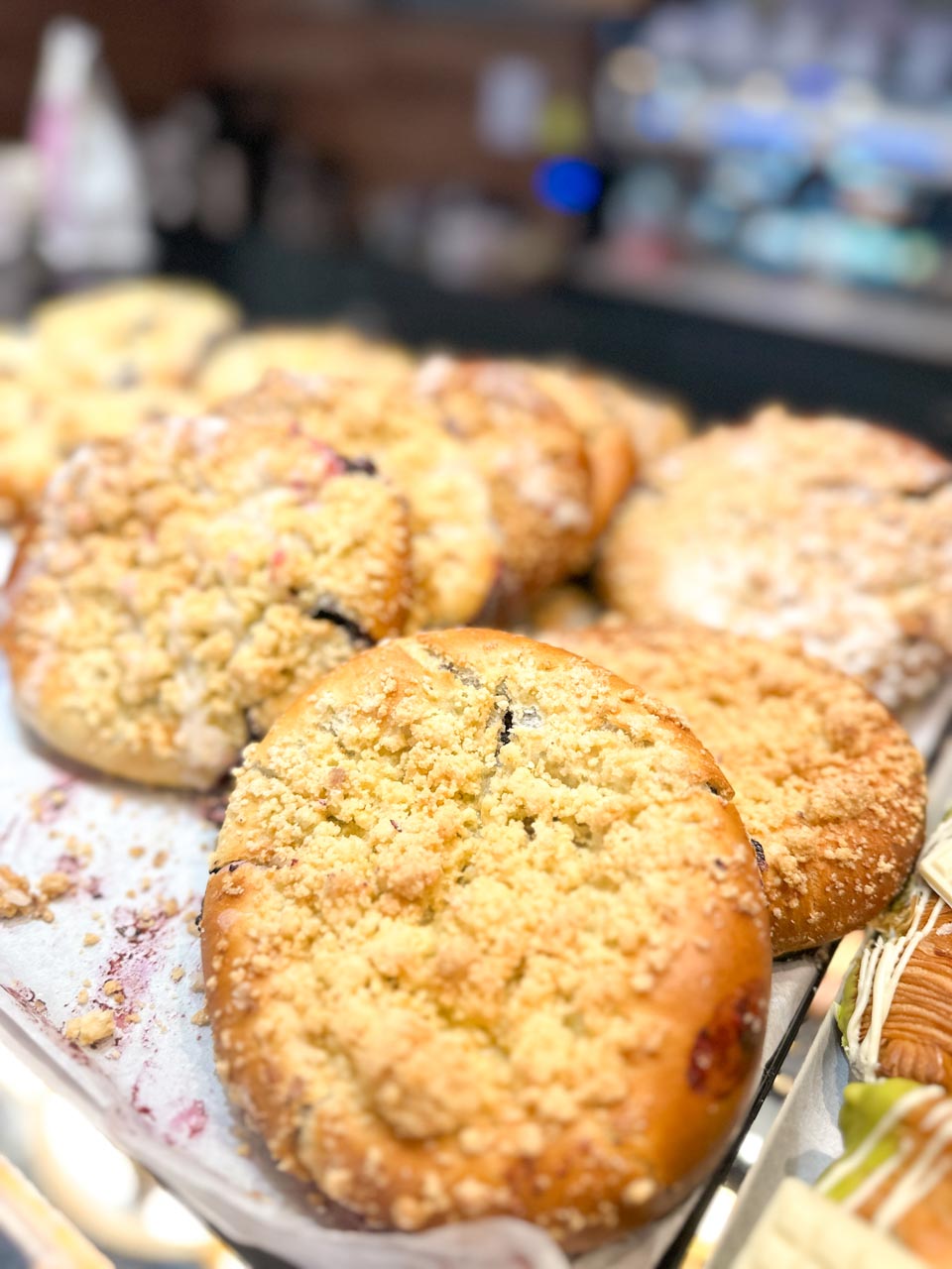 Tray of crumb-topped bilberry buns displayed at a bakery counter at Cafe Antidotum in Gdańsk