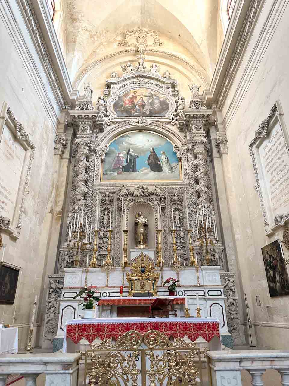 Baroque altar with statues and paintings inside Chiesa di Santa Chiara in Lecce, Italy