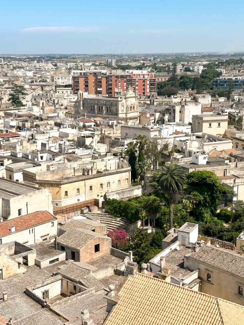 View over the rooftops of Lecce&rsquo;s historic centre with stone buildings and palm trees