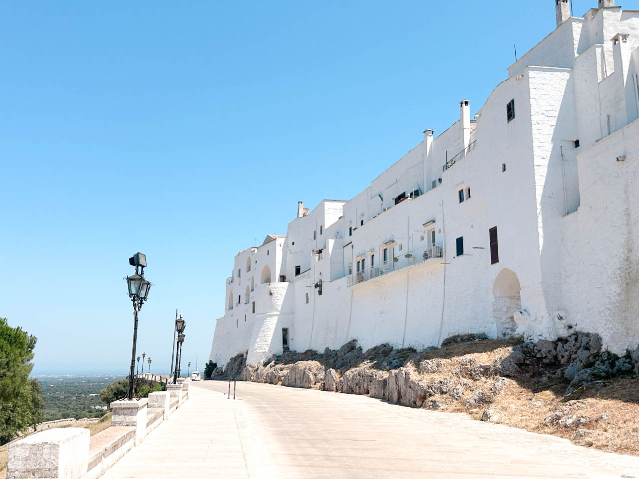 Whitewashed houses along the city walls with views over the countryside outside Ostuni, Italy