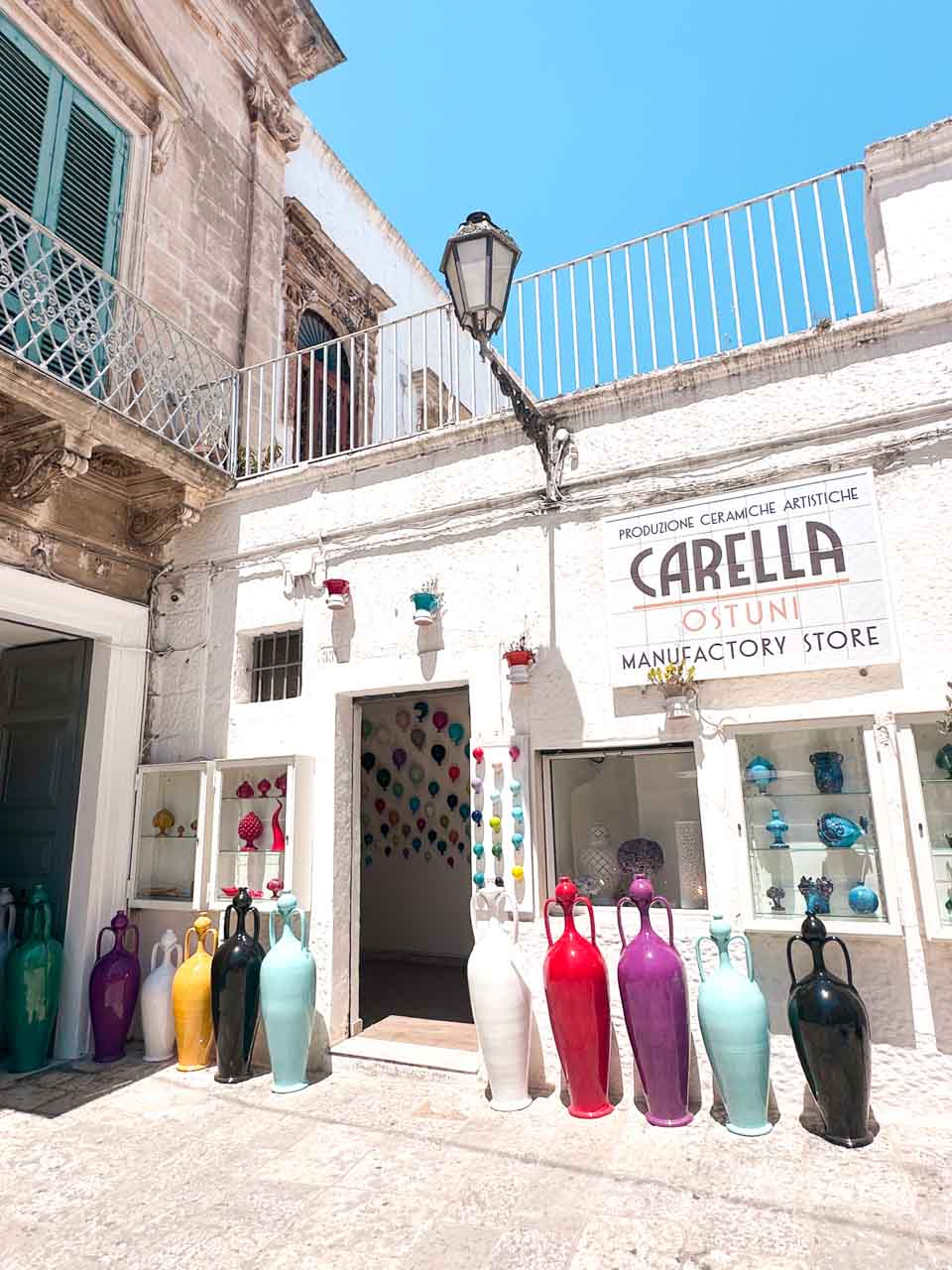 Ceramic shop in Ostuni with colourful vases displayed outside a white building