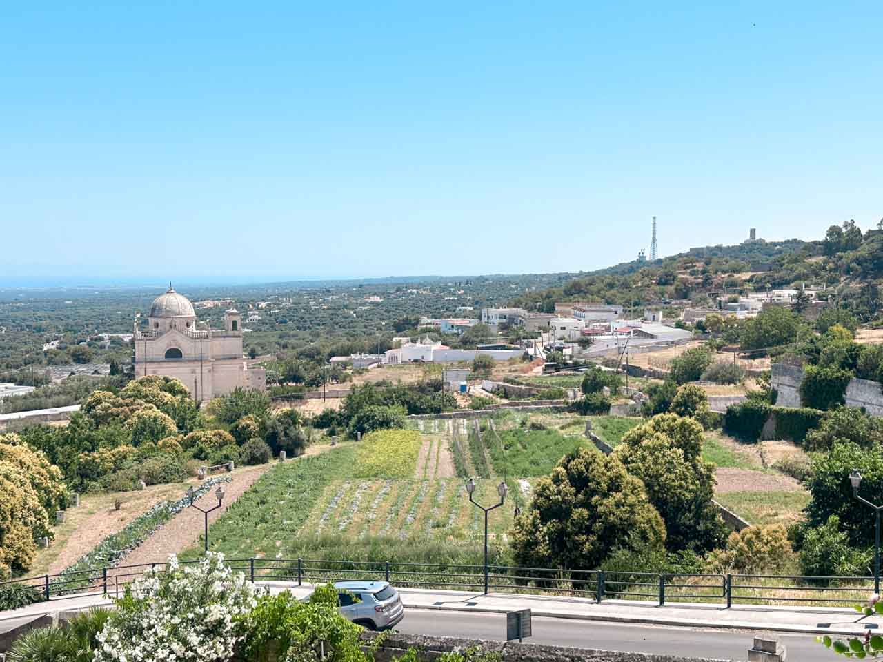 Countryside view from Ostuni with fields, a road, and a church dome below