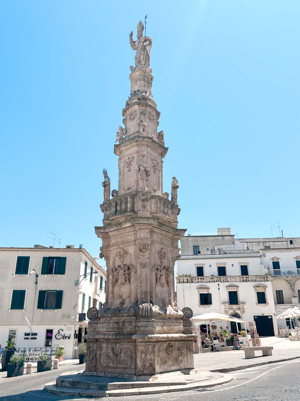 Column of Sant&rsquo;Oronzo in Piazza della Libert&agrave; in Ostuni under a clear blue sky
