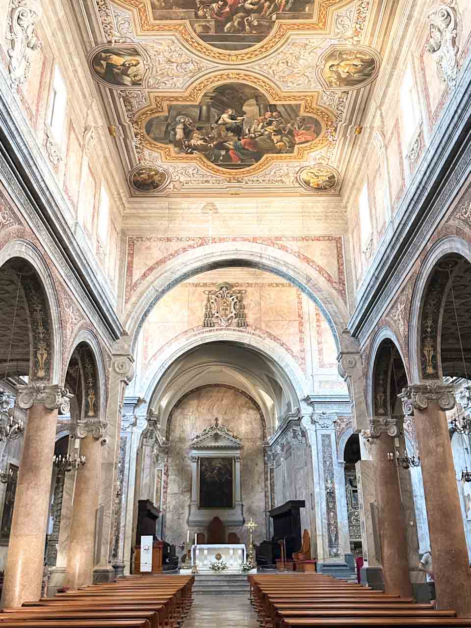 Interior of Ostuni Cathedral with a painted ceiling, arches, and an altar