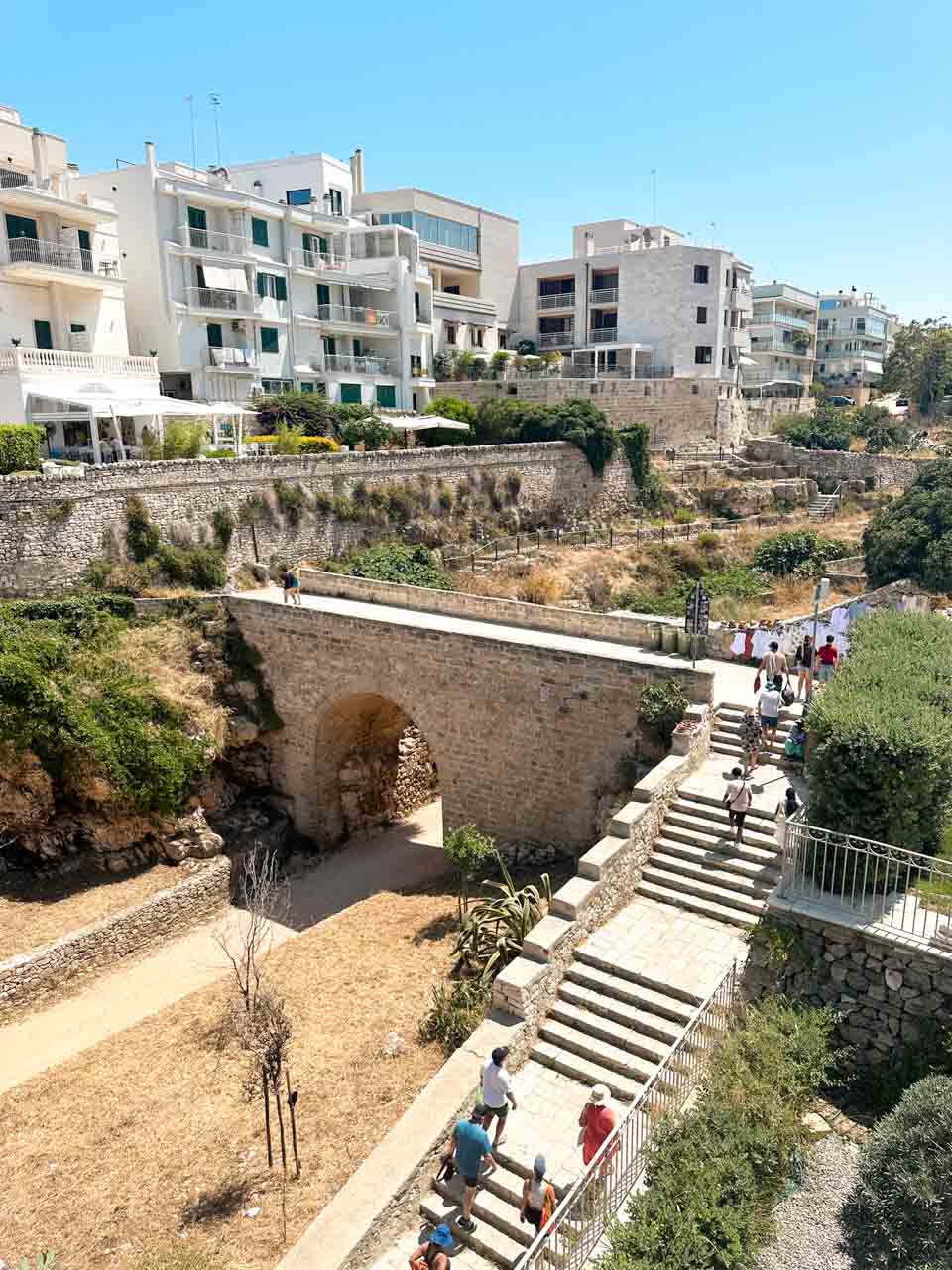 Stone bridge and steps leading down towards the Lama Monachile (Cala Porto) beach in Polignano a Mare, Italy