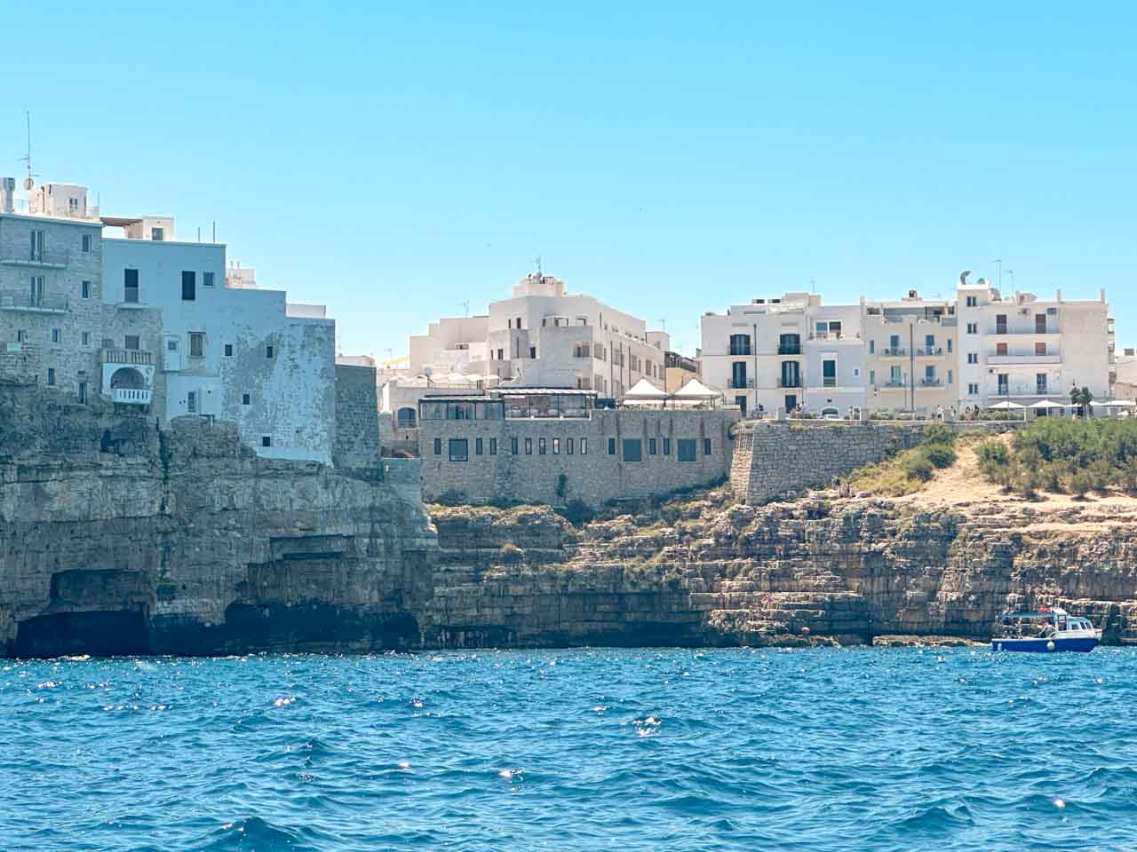 White buildings on rocky cliffs overlooking the Adriatic Sea in Polignano a Mare, Italy