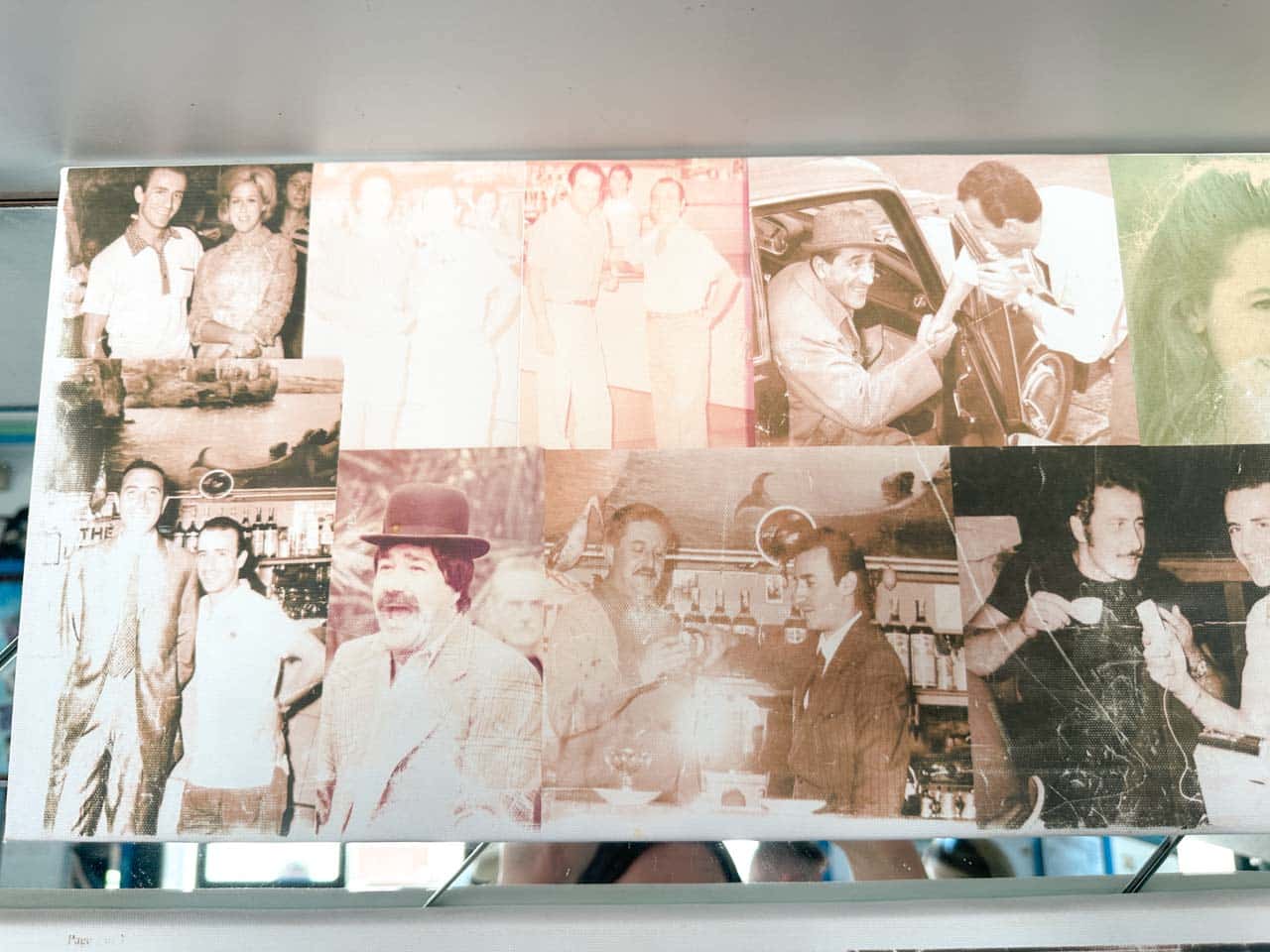 A collage of vintage black and white photographs displayed inside The Super Mago del Gelo Mario Campanella in Polignano a Mare, Italy