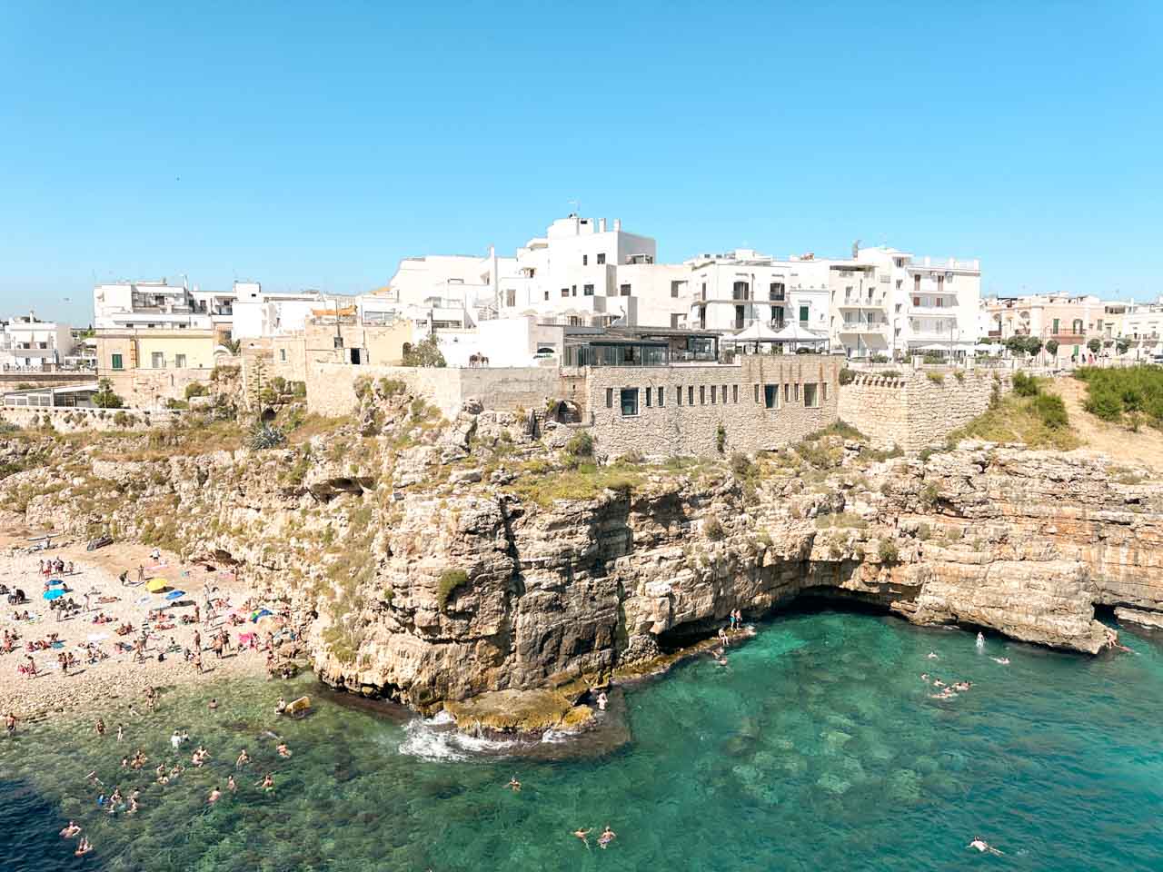 View of the Lama Monachile beach in Polignano a Mare with cliffs and white buildings above