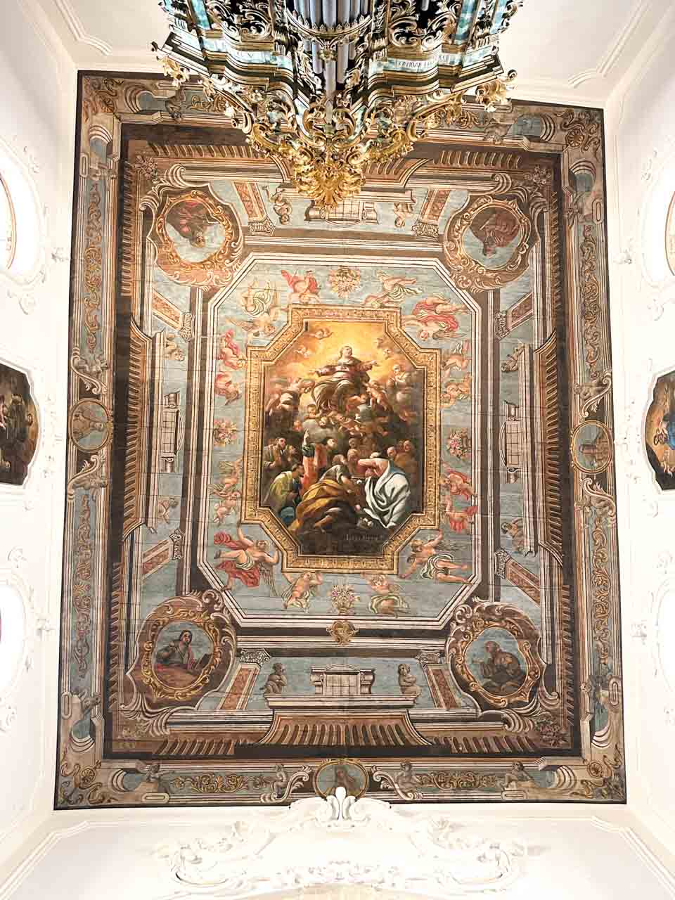 Painted ceiling with a central religious scene and decorative details at the Church of Saint Mary of the Assumption in Polignano a Mare