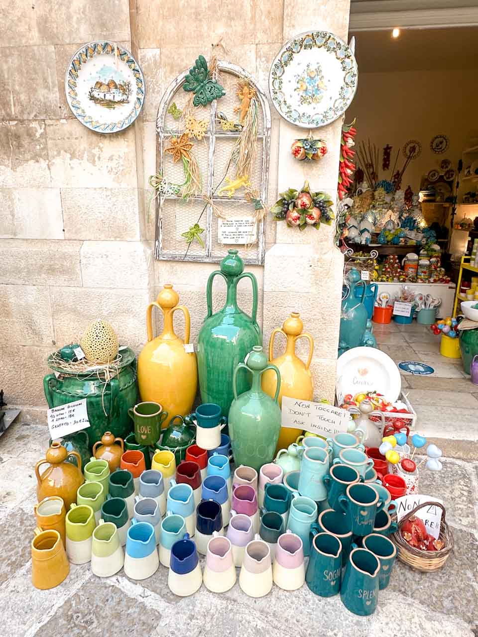 Colourful ceramic jugs displayed outside a shop in Polignano a Mare, Italy