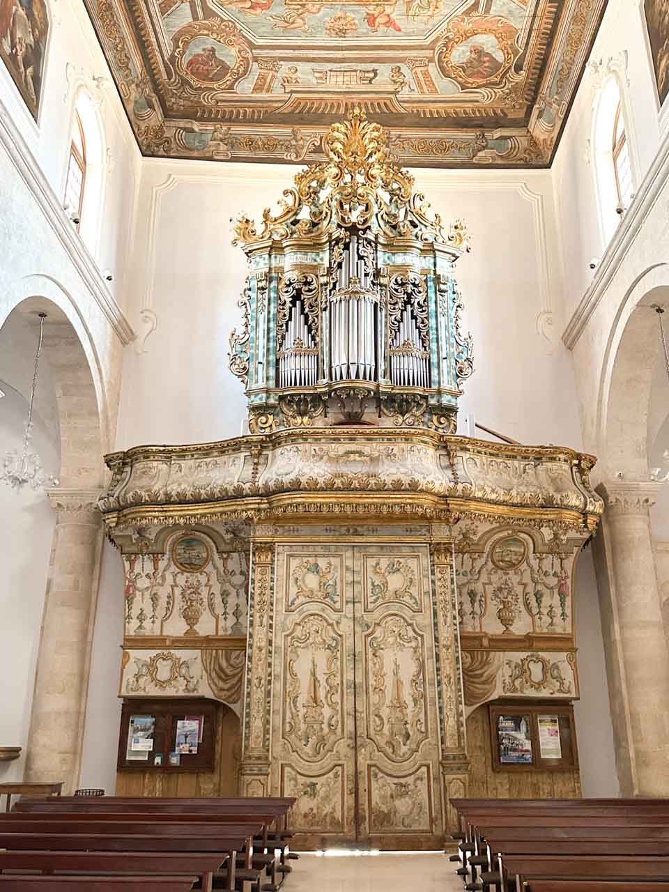 A pipe organ and a painted ceiling inside the Church of Saint Mary of the Assumption in Polignano a Mare