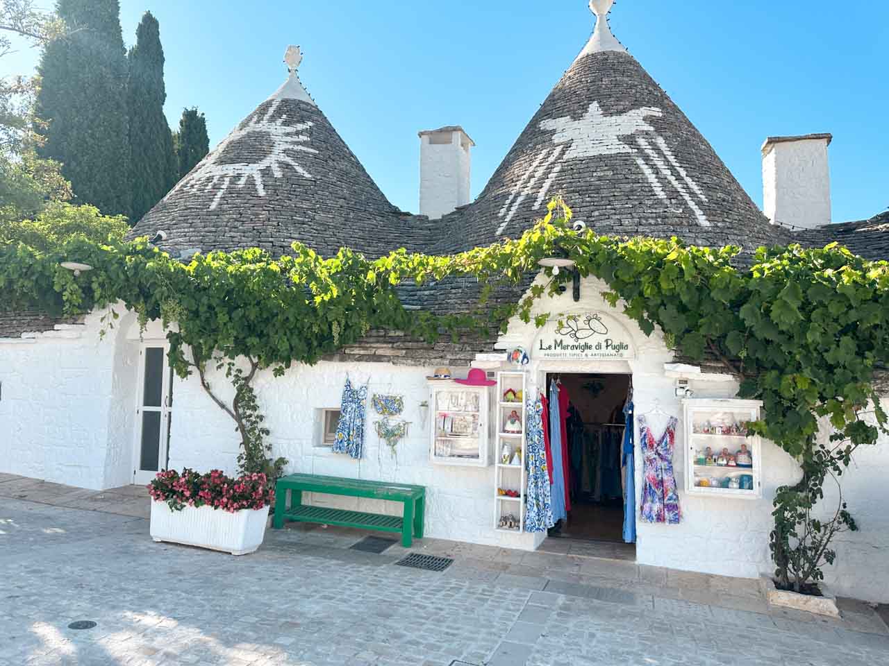 Souvenir shop in a trullo building with painted roof symbols and grapevines in Alberobello