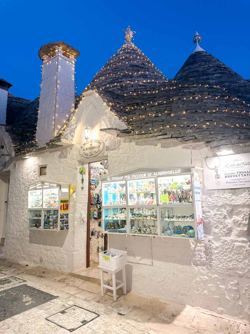Souvenir shop inside a trullo with bright displays and fairy lights