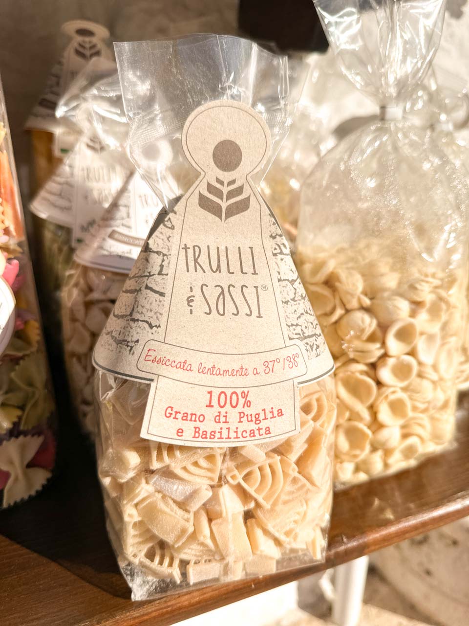 Close-up of packaged trulli-shaped pasta labelled “Trulli e Sassi” in a shop in Alberobello, Italy