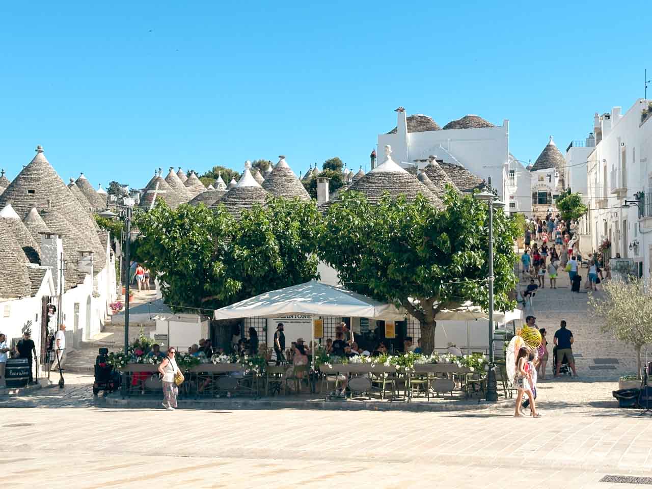 Outdoor café surrounded by trulli houses in the Rione Monti district of Alberobello, Italy