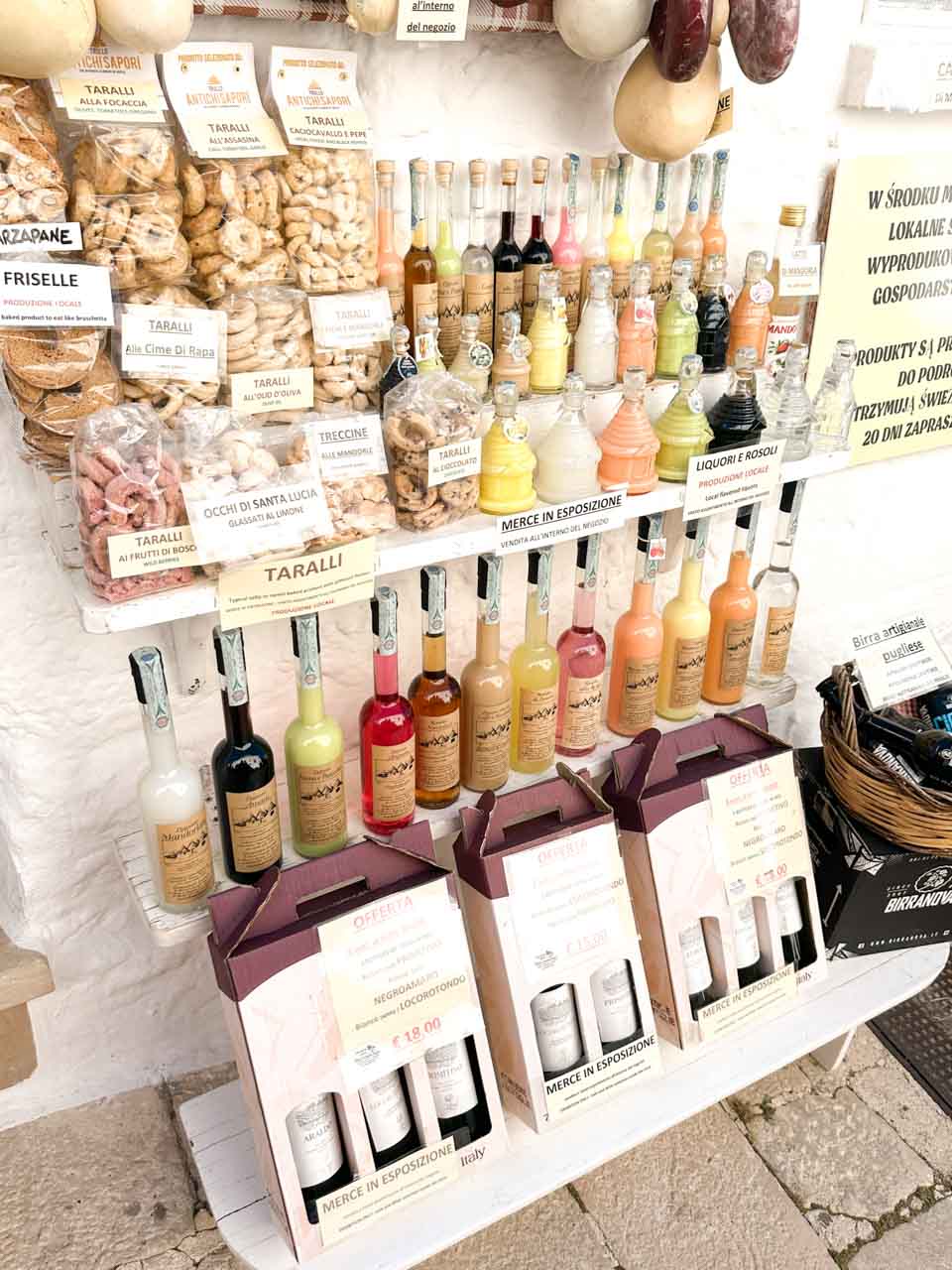 Display of local liqueurs, taralli, and regional products in a shop in Alberobello, Italy