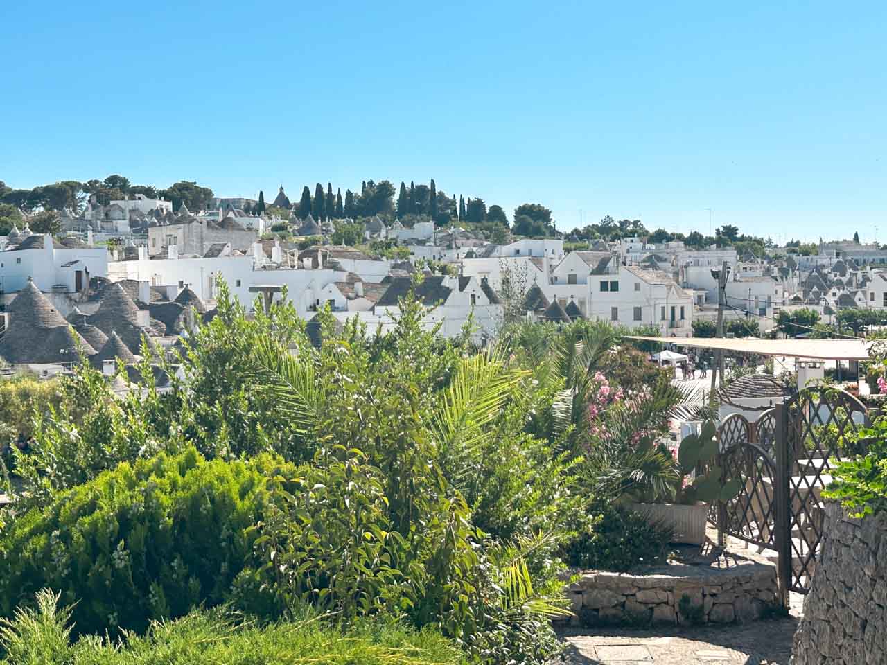 View over trulli rooftops and gardens in Alberobello on a sunny afternoon