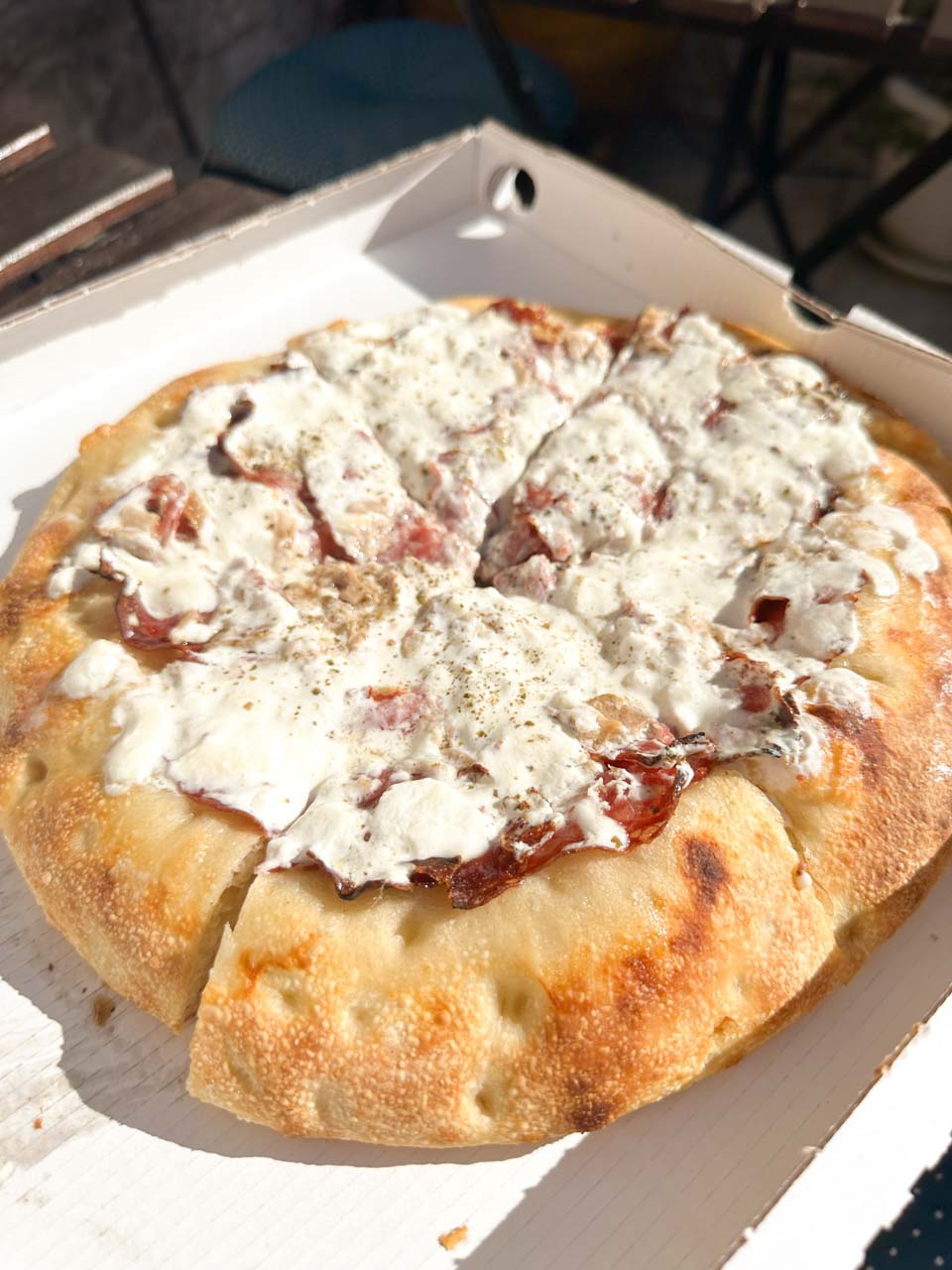 A Pasqualira focapizza topped with creamy stracciatella and cured meat served in Alberobello