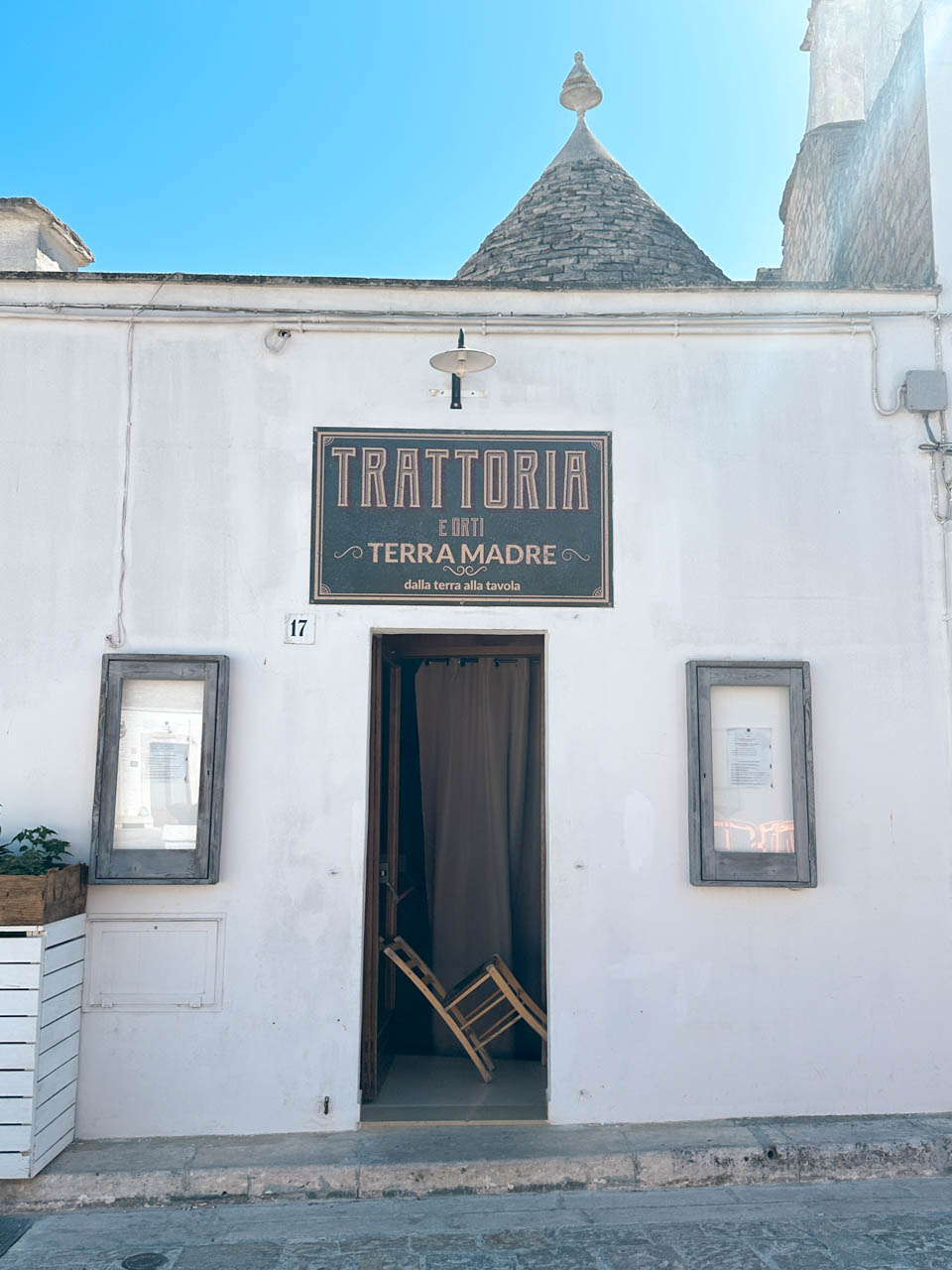Entrance to Trattoria Terra Madre, a restaurant serving traditional Puglian cuisine in Alberobello, Italy